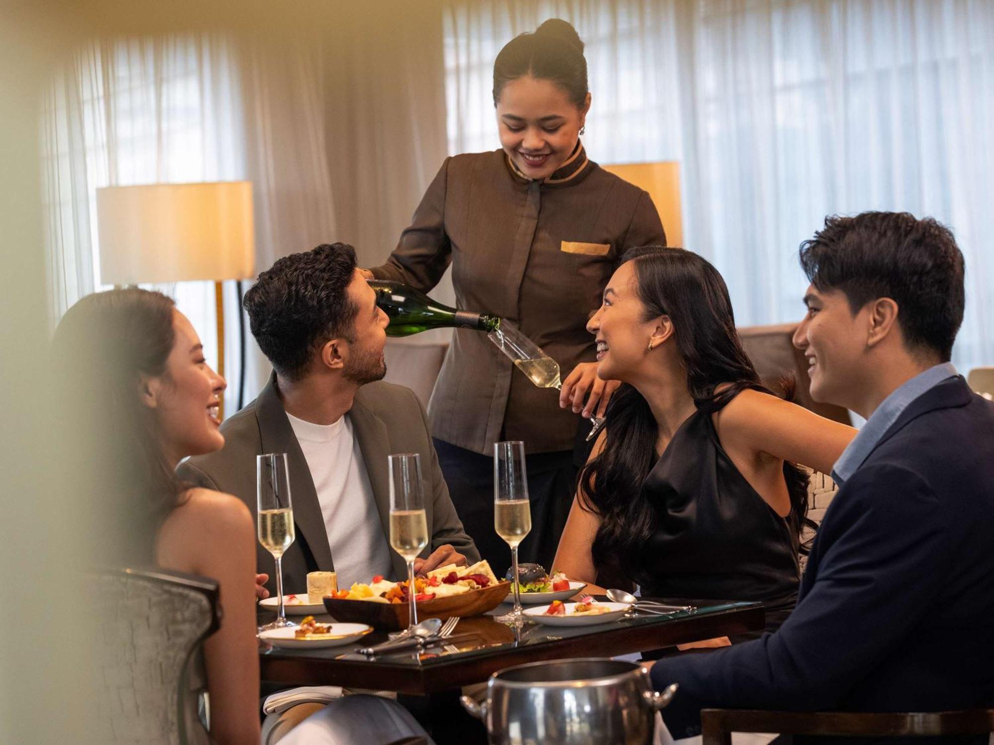 Fairmont Makati Hotel San Pedro Makati Eksteriør billede A butler serving drinks at a party